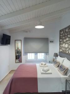 1 dormitorio con 1 cama grande y 2 almohadas en Elia House 3 near Nafpaktos, en Lóngos