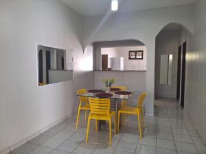 una sala da pranzo con tavolo e sedie gialle di Casa a 2km da praia do Aracagy a São Luís