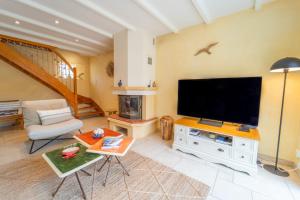 sala de estar con TV de pantalla plana grande en Confortable maison joliment décorée, en Les Sables-dʼOlonne