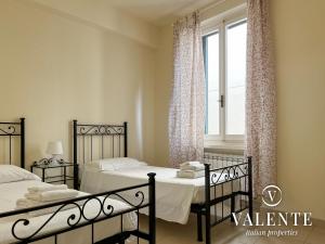een slaapkamer met 2 bedden en een raam bij Spazioso alloggio con ascensore in Borgo a Buggiano