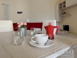 a table with a red tea pot and glasses on it at Spazioso alloggio con ascensore in Borgo a Buggiano