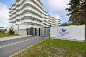 a gate in front of a building with aidium perl sign at Rogowo Pearl Turquoise Apartments Near The Sea with FREE PARKING by Renters in Rogowo