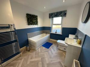 a bathroom with a tub and a toilet and a sink at Home Away From Home - Perfect For Contractors in Newark upon Trent