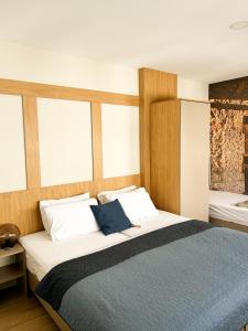 a bedroom with a large bed with wooden walls and windows at Urban Residence Apartments in Mostar