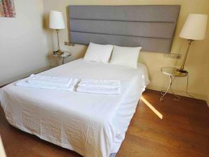 - une chambre avec un grand lit blanc et deux lampes dans l'établissement Home nearby timeout, à Lisbonne