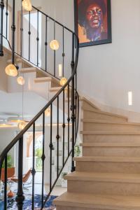 een trap in een huis met zwarte leuningen en een schilderij bij VILLA LA ROMANELLA in Carry-le-Rouet