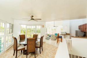 comedor y sala de estar con mesa y sillas en Villa Dance - Home with Steps to the Beach, en Cabarete