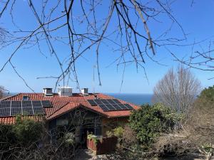 una casa con paneles solares en el techo en Apartamentos Mar y Mar Agroturismo, en San Sebastián