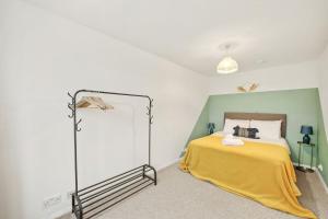 een slaapkamer met een bed met een gele deken bij June Disc - Long Stay - Contractors in Swindon