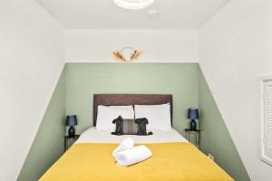 a bedroom with a large bed with a yellow blanket at May Disc - Long Stay - Contractors in Swindon