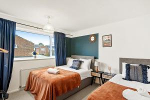 a bedroom with two beds and a window at May Disc - Long Stay - Contractors in Swindon