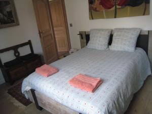 - une chambre avec un lit et 2 serviettes roses dans l'établissement Bienvenue à Saint Prix, à Saint-Prix