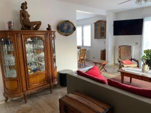 - un salon avec un meuble en bois et un canapé dans l'établissement Bienvenue à Saint Prix, à Saint-Prix