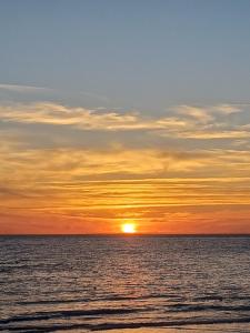 um pôr-do-sol sobre o oceano com o pôr-do-sol em Studio tout confort à 500 m de la mer em Bretignolles-sur-Mer