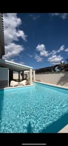 una piscina de agua azul frente a una casa en La Costa B&B, en Flumini di Quartu