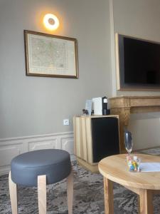 uma sala de estar com um banco azul e uma televisão em Hotel Le Cercle em Cherbourg en Cotentin