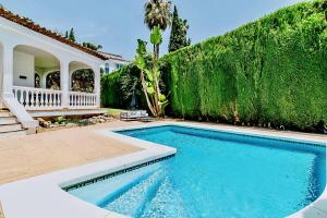 a swimming pool in front of a house at 4 bedroom Villa in Top location - Heating Pool in Marbella