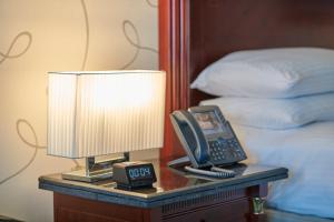 a lamp and alarm clock on a table next to a bed at Intercontinental Cairo Citystars, an IHG Hotel in Cairo