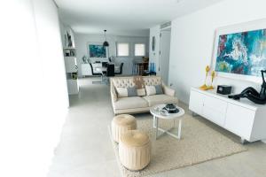 uma sala de estar com um sofá e uma mesa em Casa Tranquilidade - Casa moderna com piscina em Guimarães