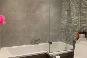 a bathroom with a bath tub with a glass shower at A quiet haven in the city in Birmingham