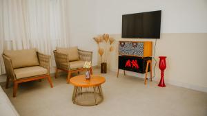 a living room with a fireplace and chairs and a tv at Casa reserva boa vista in Barreirinhas