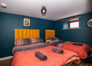 two beds in a room with blue walls at Bartholomew's Loft in Ráistín