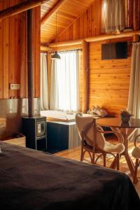 a bedroom with a bed and a table and a kitchen at Hospedaria Refugio do Invernador in Urubici