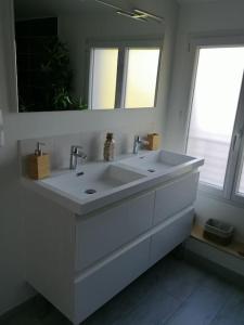 ein weißes Badezimmer mit einem Waschbecken und einem Spiegel in der Unterkunft Le Caudalie au cœur des vignobles Pessac Léognan in Léognan