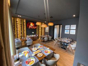 uma sala de jantar com mesas e cadeiras com pratos de comida em Hotel Flaer em Shkodër