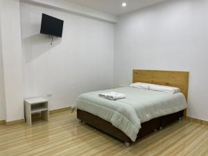 a bedroom with a bed and a flat screen tv at Hurin Hotel in Ica