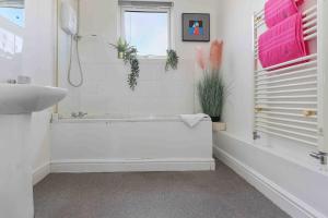 La salle de bains est pourvue d'une baignoire blanche et d'un lavabo. dans l'établissement 4 Bed House Near Trent Bridge, à Nottingham