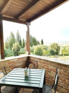 - une table de pique-nique sur une terrasse avec un mur en briques dans l'établissement Agriturismo Carpineto, à Asciano