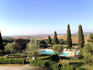 une piscine au milieu d'un jardin arboré dans l'établissement Agriturismo Carpineto, à Asciano