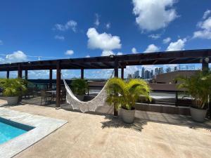 a hammock on the roof of a building at Bela Hospedagem - Marinas Flat - Excelente localização na orla de Cabo Branco in João Pessoa