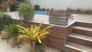ein Garten mit Topfpflanzen und einem Swimmingpool in der Unterkunft Casa Aconchegante in Saquarema