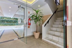 una puerta de ducha de cristal en una casa con una maceta en 945 - Apartamento Ed Estrela do Mar II - Centro Bombinhas - Garagem para 1 Carro, en Bombinhas