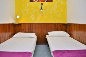 Duas camas num quarto com paredes de madeira em Condominio Adriatico em Bibione
