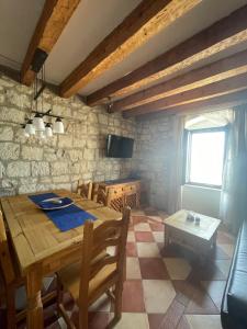 una sala da pranzo con tavolo in legno e TV di Villa Gabine a Kaštela (Castelli)