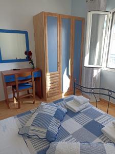 a bedroom with a bed and a table and a desk at Απεραντο Γαλαζιο in Agia Pelagia