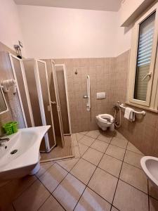 bagno con doccia, lavandino e servizi igienici di Hotel Villa Tina a Cesenatico