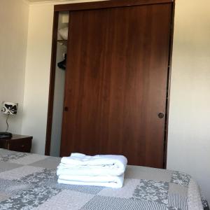 a bedroom with a bed with towels on it at AMISTAR BELLAS ARTES in Santiago