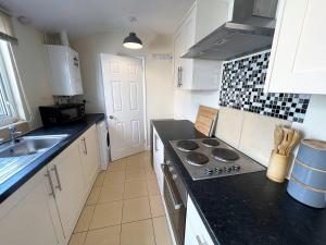 a kitchen with a stove and a sink in it at 3-bed House In Grantham in Lincolnshire