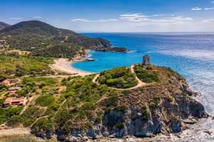 Un'isola nell'oceano con un faro sopra di Veridia Resort a Chia