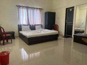 1 dormitorio con cama, lavabo y espejo en Blue Bell Homestay, en Lonavala