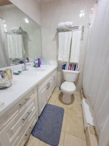 a bathroom with a toilet and a sink and a mirror at 24 Maple Gardens in Bridgetown