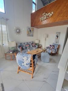 a living room with couches and a table and chairs at 24 Maple Gardens in Bridgetown