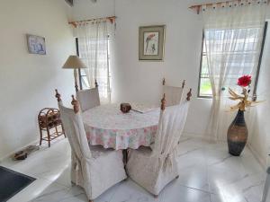 a room with a table and chairs with a vase at 24 Maple Gardens in Bridgetown