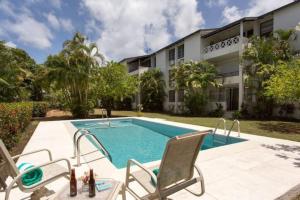 a swimming pool in front of a building at 24 Maple Gardens in Bridgetown