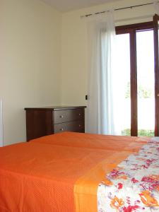 sypialnia z łóżkiem, komodą i oknem w obiekcie Borgo Nicoletta Case per le vacanze w mieście Filandari