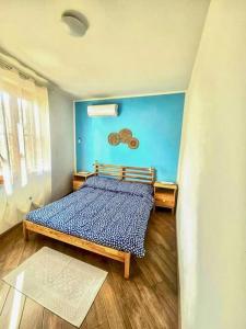 a bedroom with a bed with a blue wall at CLhome: 3 minuti dal mare in Alghero